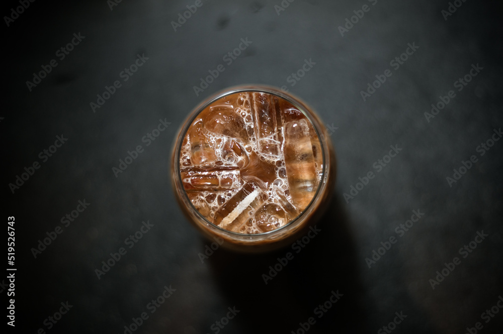 Ice coffee on a table with cream being poured into it showing the texture Ice coffee on a table with cream being poured into it showing the texture