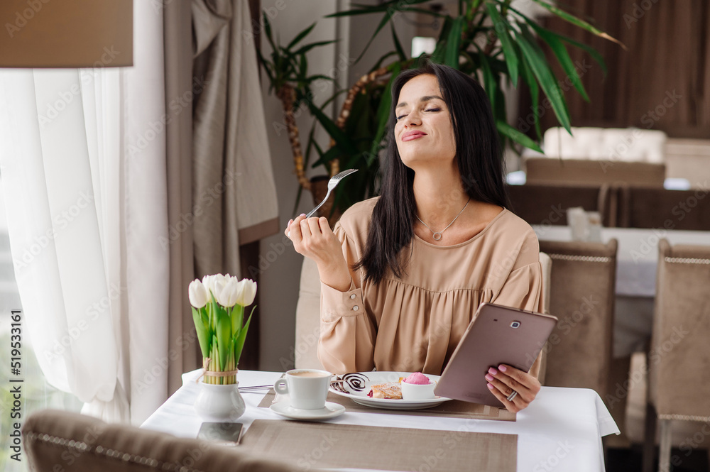 Elegant caucasian woman in dress is eating tasty sweet dessert in the cafeteria Elegant caucasian woman in dress is eating tasty sweet dessert in the cafeteria