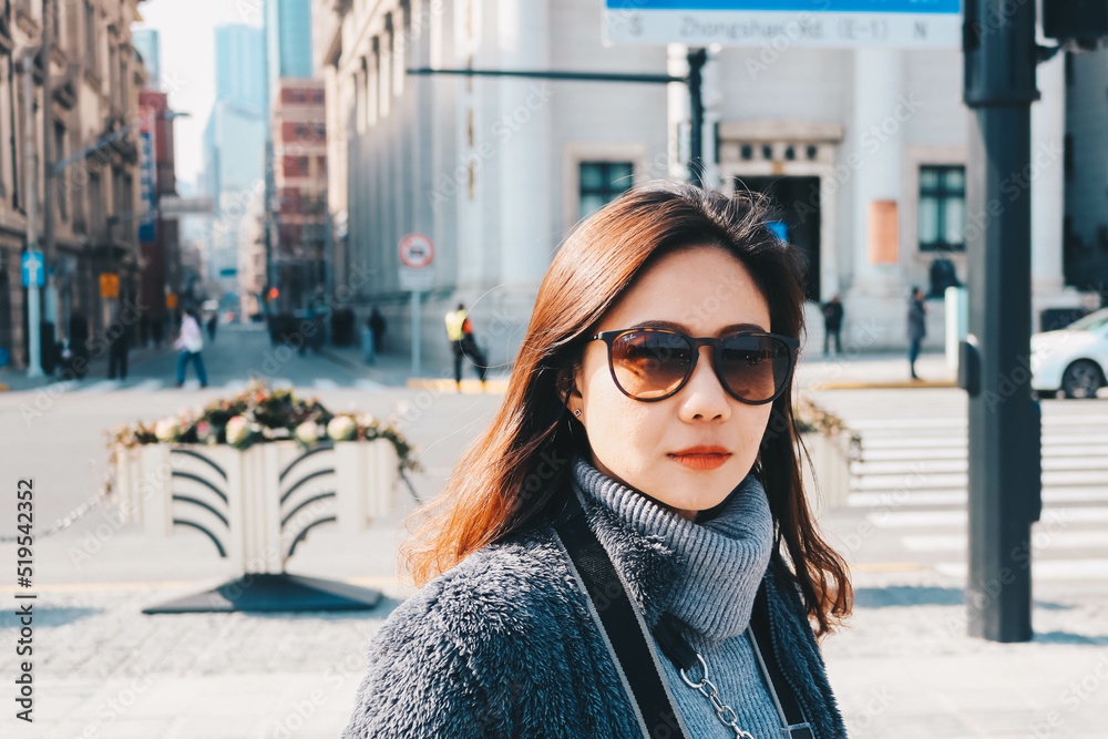 Obraz premium Beautiful young Asian woman in her winter jacket, traveler concept.