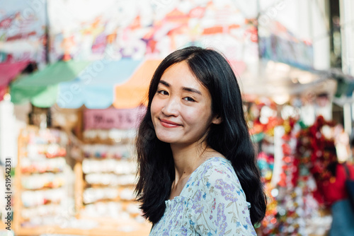 Close up of beautiful Asian woman with city blurred background.