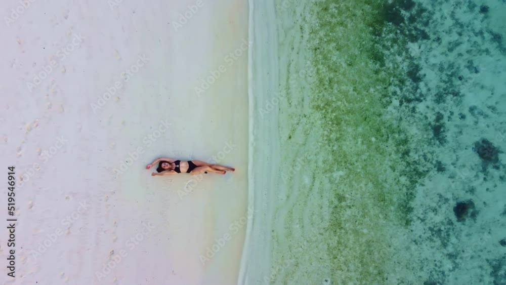 a young woman wearing a black swimsuit lies onthe ocean. a young woman wearing a black swimsuit lies onthe ocean.