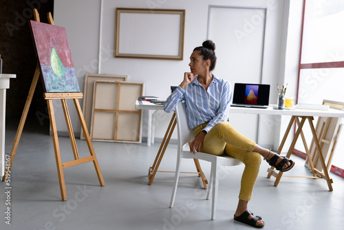 Wallpaper Mural Image of thoughtful biracial female artist sitting on chair in studio Torontodigital.ca