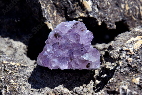 A beautiful amethyst druze lies on a stone. A splice of purple crystals of semi-precious quartz.