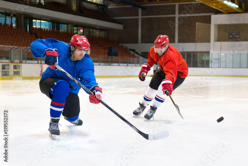Ice hockey players playing ice hockey in the ice rink in winter