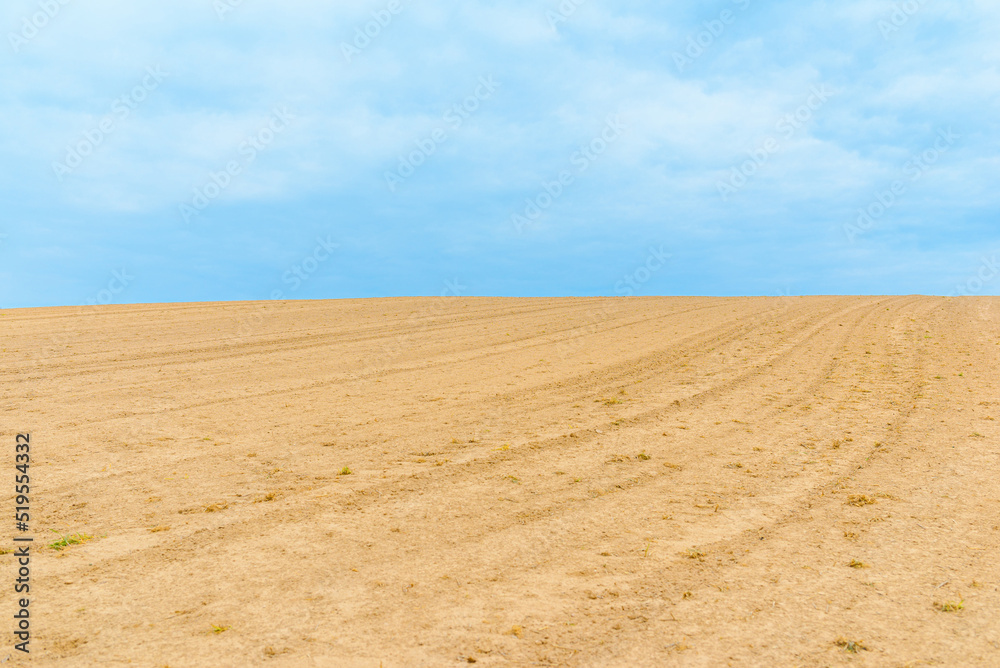 Landscape with agricultural land, in slope, recently plowed and prepared for the crop,agricultural background.Blue sky. Landscape with agricultural land, in slope, recently plowed and prepared for the crop,agricultural background.Blue sky.