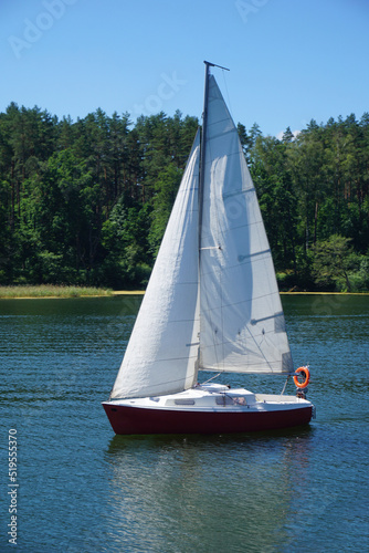Sailboat swimming on a lake - side view