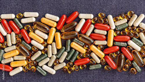 heap of pills close-up. vitamin dietary supplements on on burlap rag. immune prevention care concept photo
