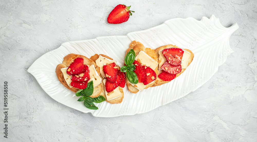 Two toasts or bruschetta with trawberries, cheese camembert nuts and honey. Summer breakfast. Healthy, clean eating. Vegan or gluten free diet