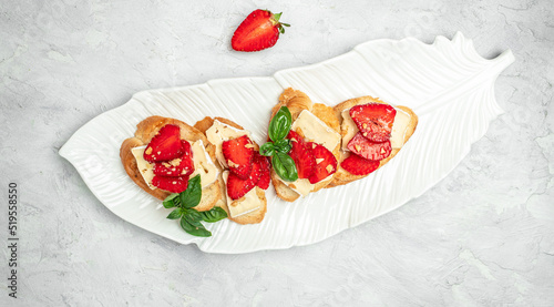 Two toasts or bruschetta with trawberries, cheese camembert nuts and honey. Summer breakfast. Healthy, clean eating. Vegan or gluten free diet