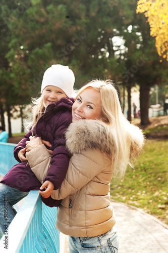 Cute happy girl hugging her mother in autumn park © LP Design
