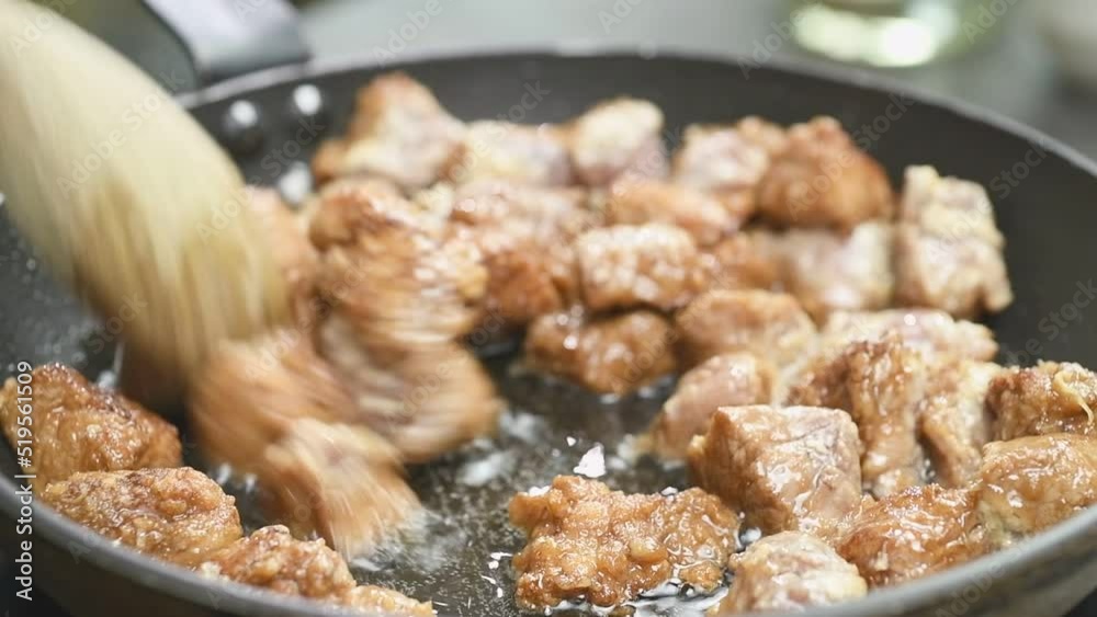 Cooking pieces of pork in a frying pan.
Cooking pieces of pork in a frying pan.