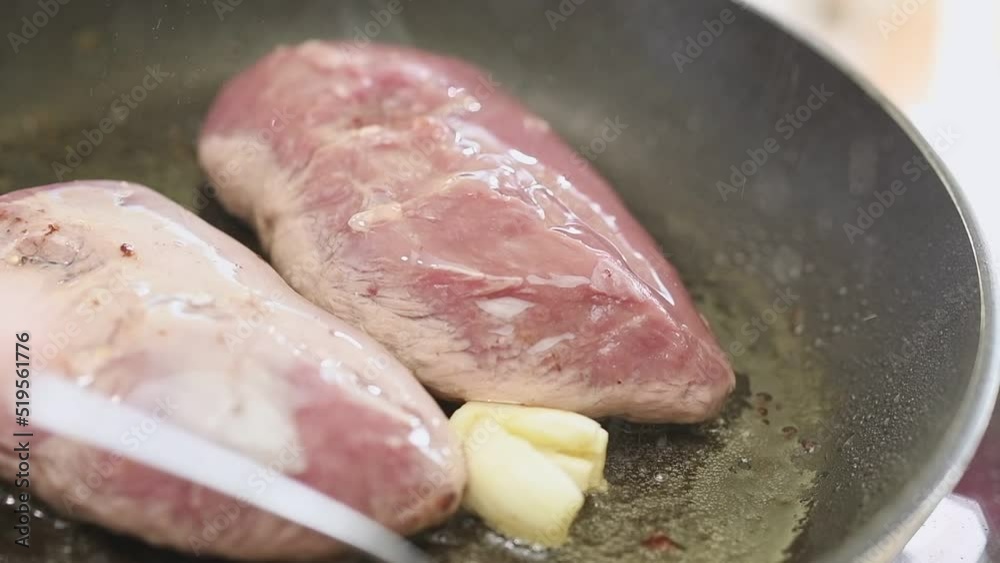 Cooking duck breasts in a frying pan.
