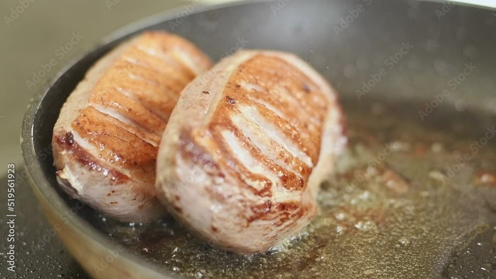 Cooking duck breasts in a frying pan.
