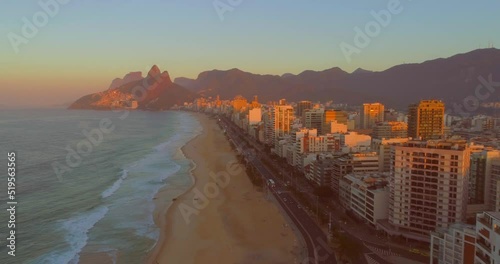 Rio de Janeiro sunrise past buildings on ipanema beach with mountains in the background photo