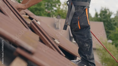 Roofer placing roof tiles on top to prepare solar panel installation, side view photo