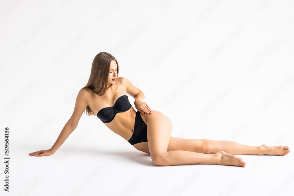 Young woman in black underwear laying down on the white background
