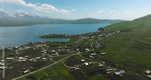 Vibrant blue Tabatskuri lake and rural village, located far from urban world. photo