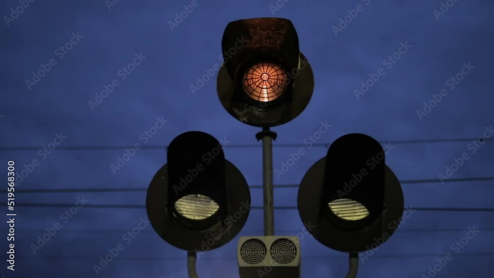 Sign of railway level crossing with flashing signal lights at night