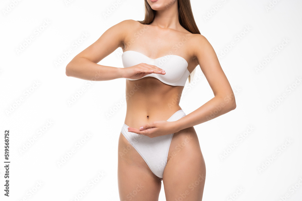 Close up view of stomach. Beautiful woman with slim body in underwear on white background.