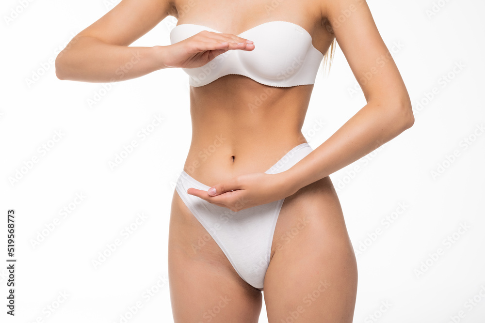Close up view of stomach. Beautiful woman with slim body in underwear on white background.