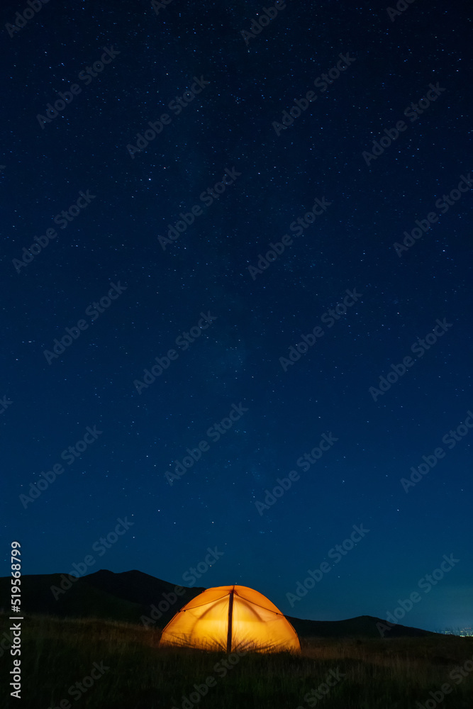 Starry sky above a tourist tent in the mountains.