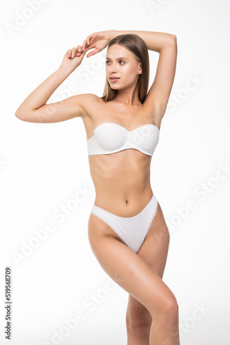 Slim tanned woman's body. Perfect body in white lingerie on white background. Beauty and body care concept