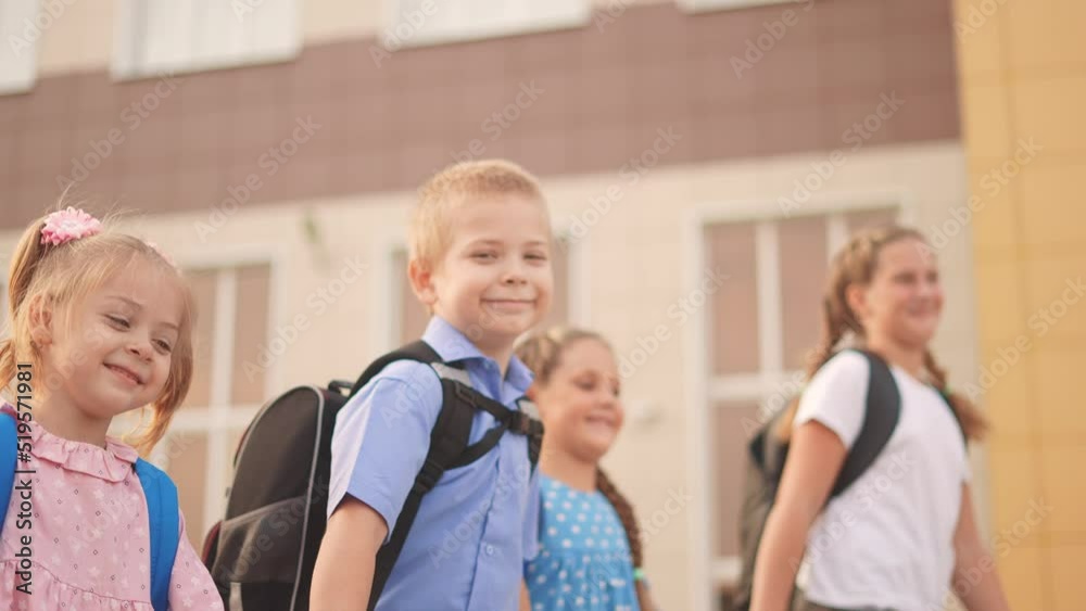 back to school. a group of schoolchildren with backpacks walk next to the school. education kids concept. lifestyle schoolboy and schoolgirl going to school. a group of children walking back to school. a group of schoolchildren with backpacks walk next to the school. education kids concept. lifestyle schoolboy and schoolgirl going to school. a group of children walking