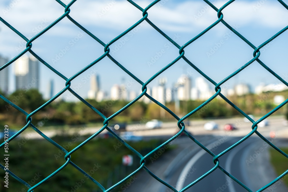 City skyline behind the wires, out of focus background. Beautiful view of the lower city skyline behind a wire fence. City skyline behind the wires, out of focus background. Beautiful view of the lower city skyline behind a wire fence.