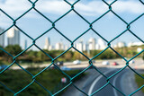 City skyline behind the wires, out of focus background. Beautiful view of the lower city skyline behind a wire fence.