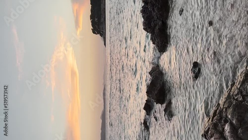 Beautiful blonde girl looking at the sunset over the rocky shore at Babin Kuk Beach with Otocic Daksa in the distance in Dubrovnik, Croatia photo