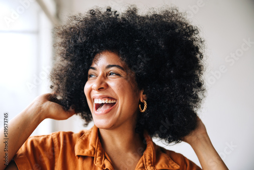 Black businesswoman with Afro hair smiling happily in an office