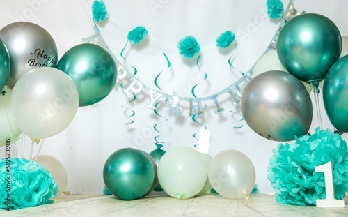 sliver, blue and white decoration for a 1st birthday cake smash studio photo shoot with balloons, paper decor, cake and topper