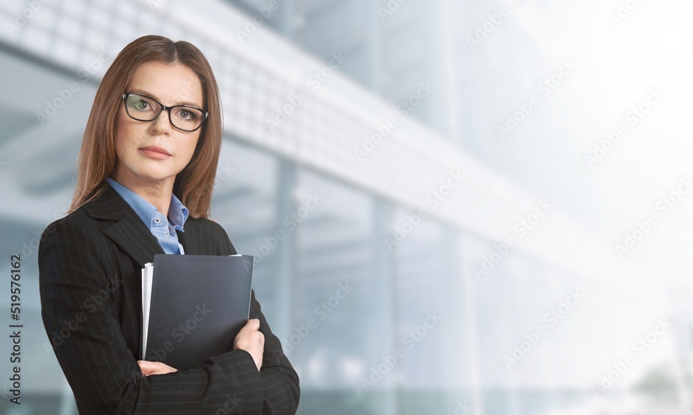 Happy attractive young businesswoman standing alone