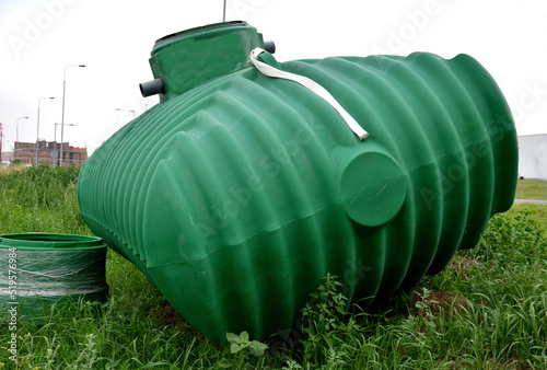 green plastic retention tank, rainwater tank with round neck and honeycomb ribbing. rainwater is purified, sedimented and stored, watered, is intended to be buried under the top of the terrain photo