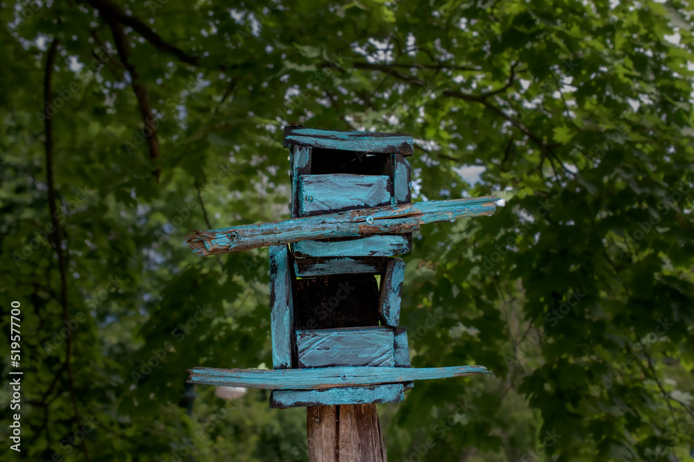 A very rough-made bird house or maybe a feeder on display in a yard in Woodstock in Upstate NY. An abstractly built birdhouse is painted a bright blue but has faded over the years. A very rough-made bird house or maybe a feeder on display in a yard in Woodstock in Upstate NY. An abstractly built birdhouse is painted a bright blue but has faded over the years.