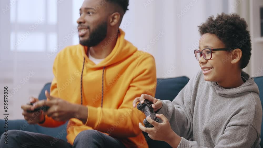 Happy young man playing video games with little brother, family having fun