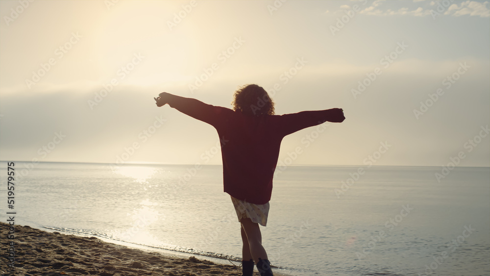 Positive woman silhouette raising hands at seaside. Emotional girl feeling happy
