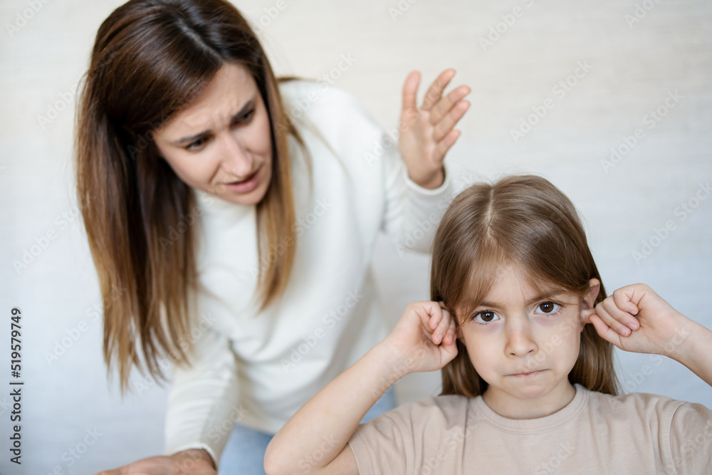 Daughter closing ears while mother scolding her. Daughter closing ears while mother scolding her.