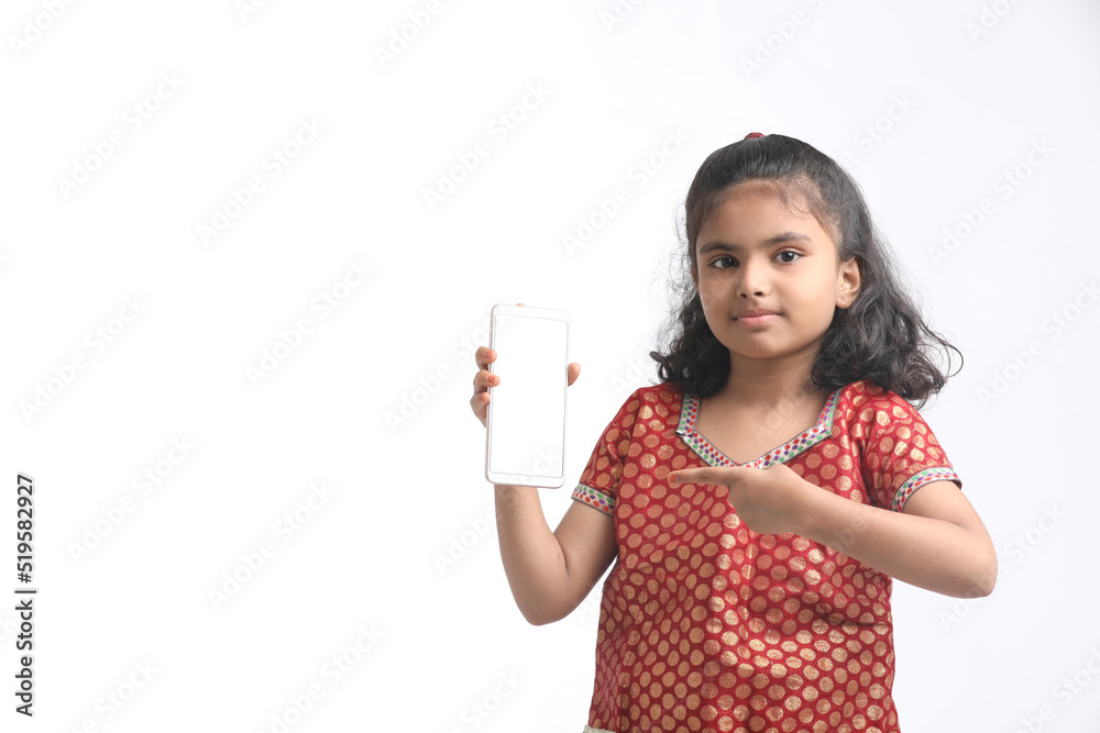 Cute indian little girl showing smartphone on white background Cute indian little girl showing smartphone on white background