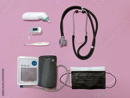 stethoscope, pulse oximeter, thermometers, blood pressure monitor, medical masks on a pink background
 photo