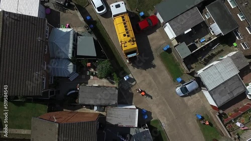 aerial view of refuse collecting lorry collecting domestic rubbish from homes on Sutton Park using the wheelie bin system to empty the rubbish into the truck, City waste manage and recycling in the ci photo