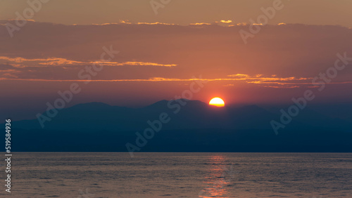 Sun is setting behind big mountain at Garda Lake