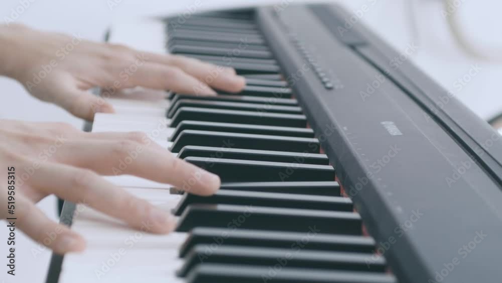 A girl plays the electric piano, detail hands and keys A girl plays the electric piano, detail hands and keys