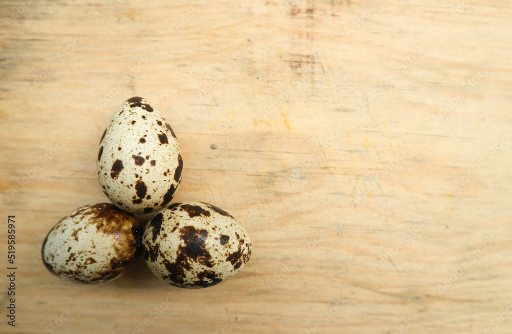 three quail eggs on a cutting board three quail eggs on a cutting board