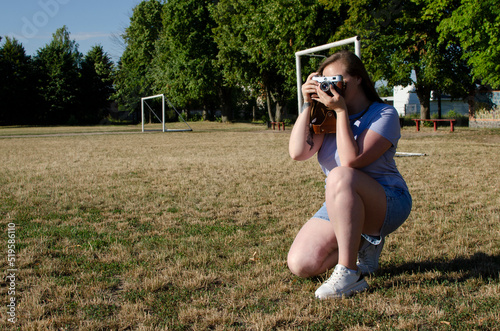 Young woman taking picture with an old/vintage film camera	 photo