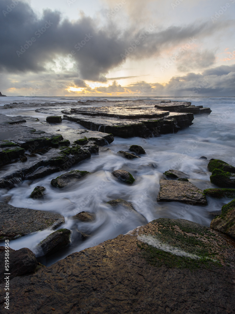 Obraz premium High tide ocean water flowing around rocks.