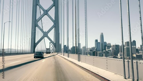 View through the windshield of a car driving over the Oakland Bay Bridge in San Francisco. View of Downtown San Francisco from the bridge. photo