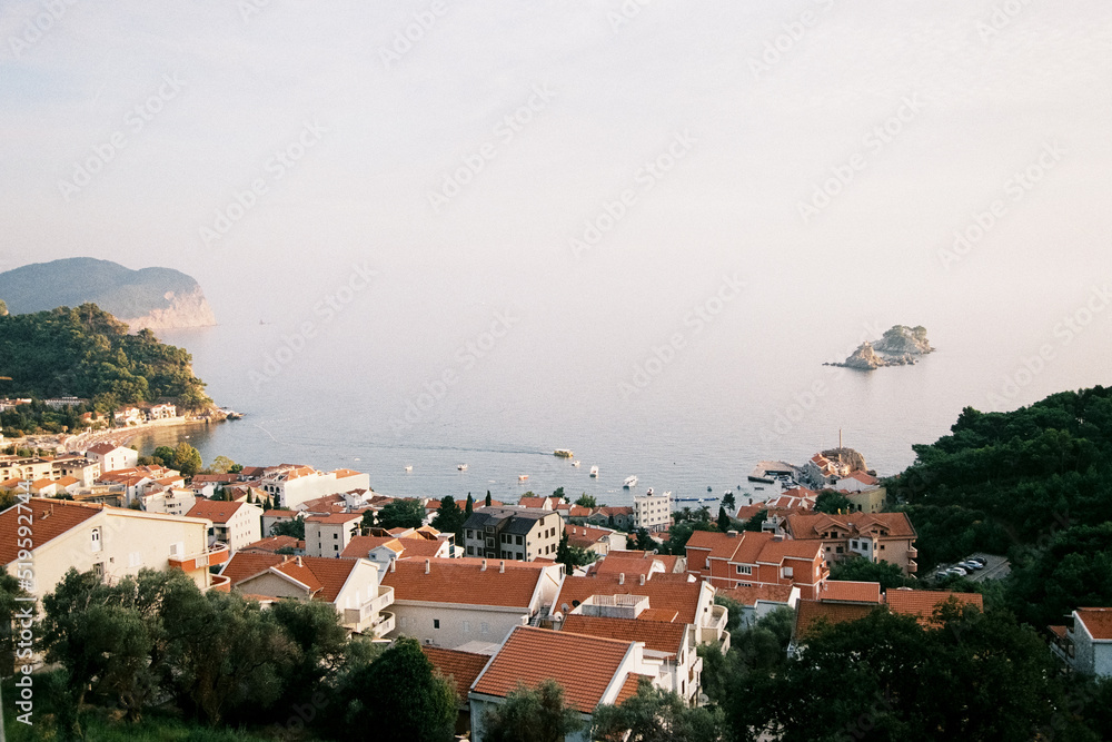 Houses with orange roofs and the sea in Petrovac, Montenegro. Grainy film in the style of old photos