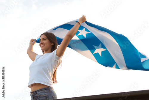 latina girl from guayaquil smiles as she holds the city's flag in honor of the independence celebrations on october 9th. photo