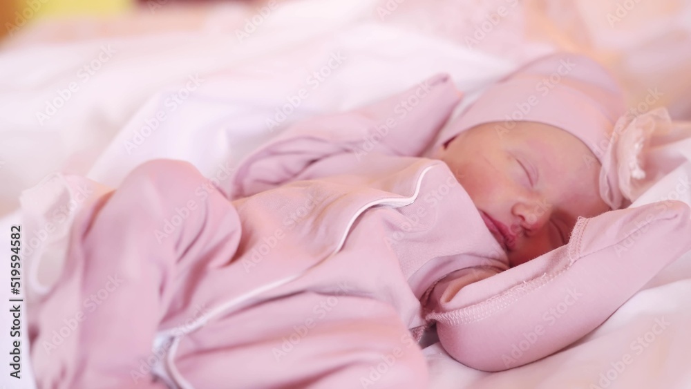 baby in a hat sleeping. newborn baby girl lifestyle sleeping in bed in a hat at home. happy